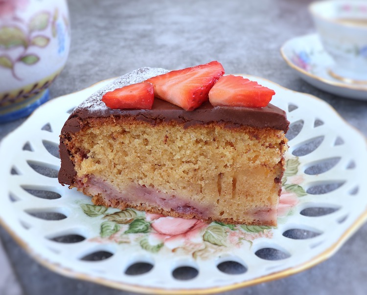 Slice of strawberry cake with chocolate frosting on a plate