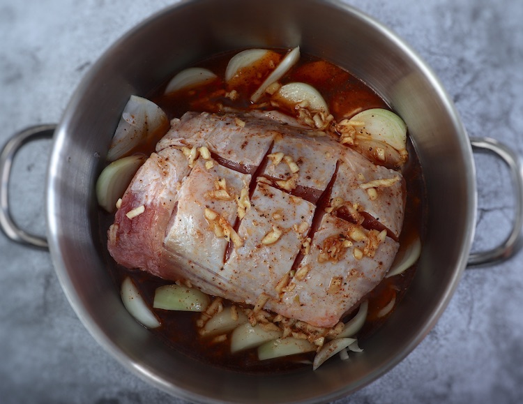 Pork loin seasoned with spices and beer on a large saucepan