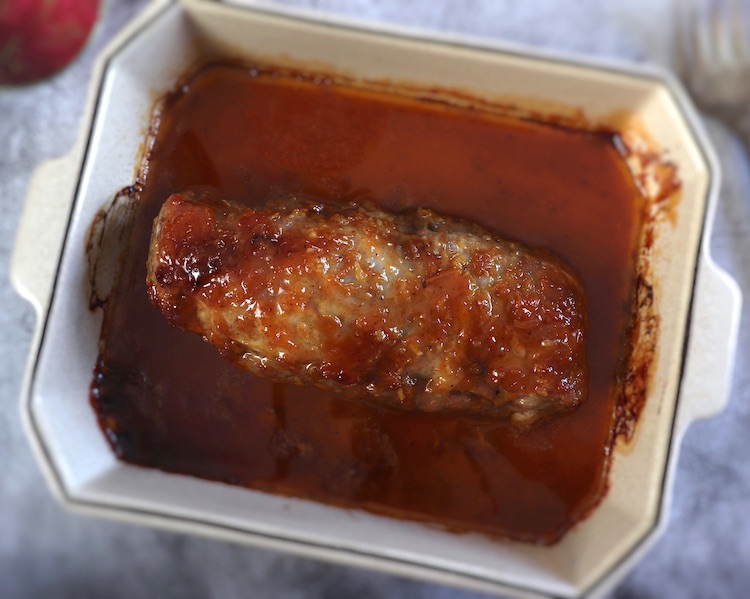 Baked pork tenderloin with honey and mustard on a baking dish