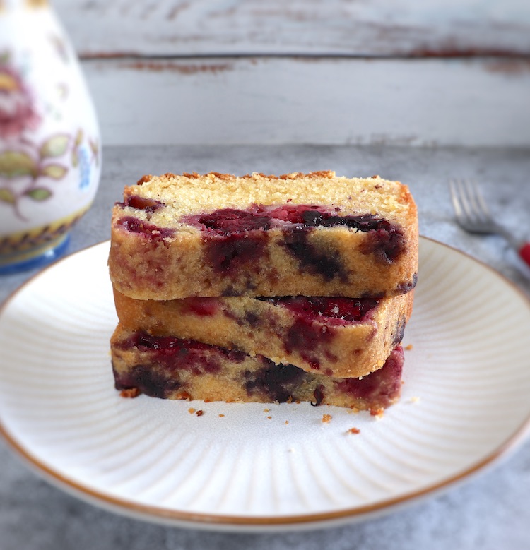 Easy triple berry loaf cake slices on a plate