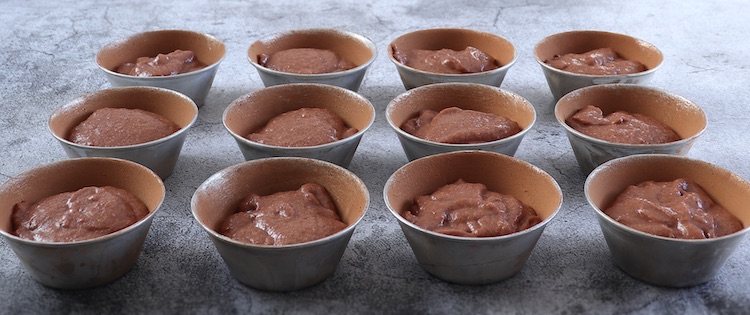Dough of cocoa strawberry muffins on muffin tins