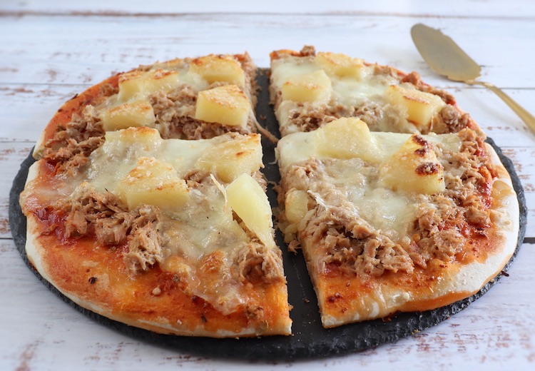 Pizza de queijo caseira com atum e ananás numa mesa