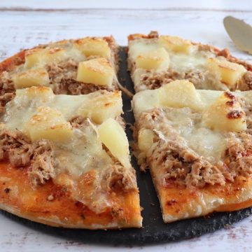 Homemade cheese pizza with tuna and pineapple Recipe on a table