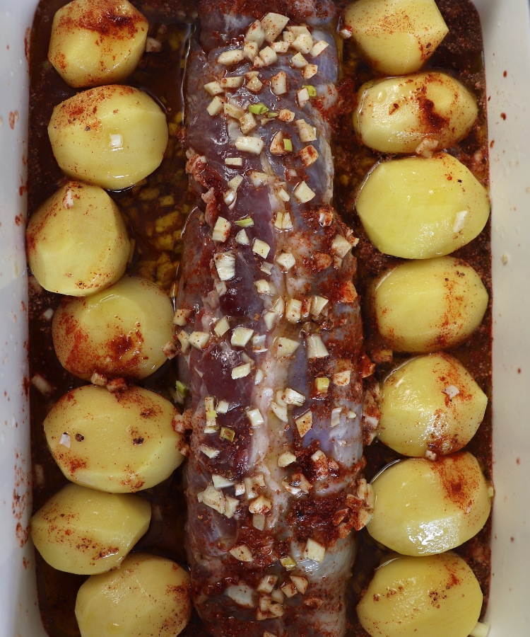 Lombinho de porco e batatas temperado com sal, pimentão doce, noz-moscada, alhos picados, sumo de limão e azeite numa assadeira