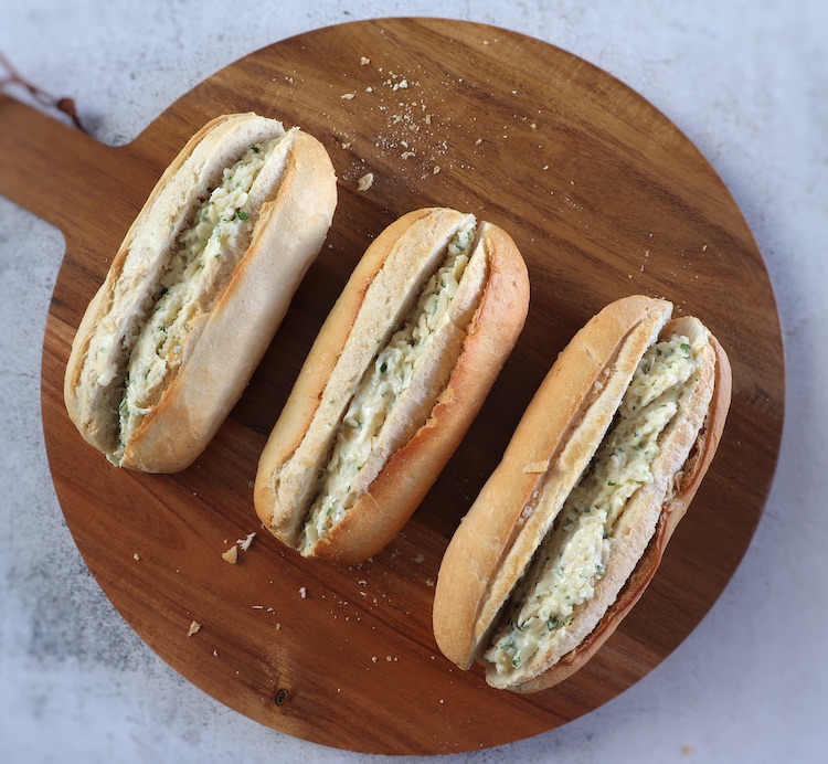 Pão simples com queijo e alho numa tábua de madeira