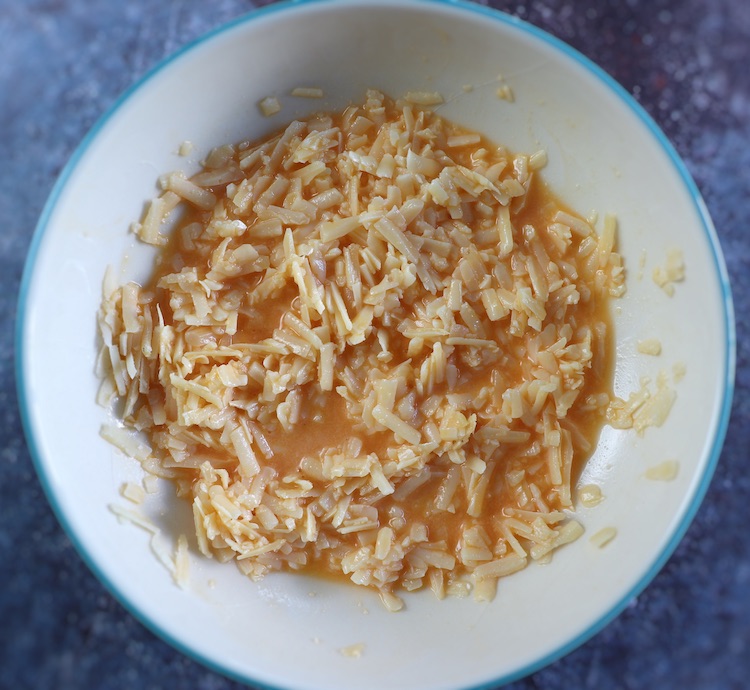 Beaten eggs and grated Parmesan cheese on a dish bowl