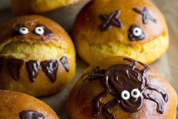 Halloween pumpkin buns on a tray lined with parchment paper
