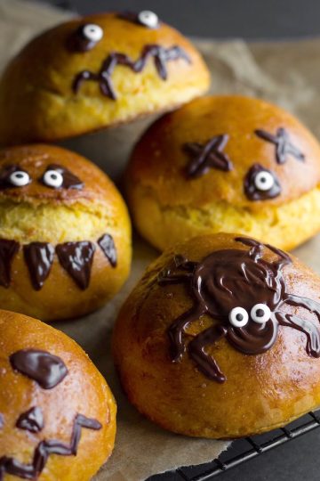 Halloween pumpkin buns on a tray lined with parchment paper