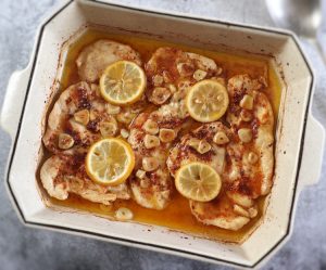Baked chicken steaks with lemon on a baking dish