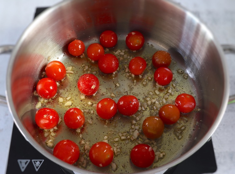 Tomate cherry, alhos picados e azeite num tacho