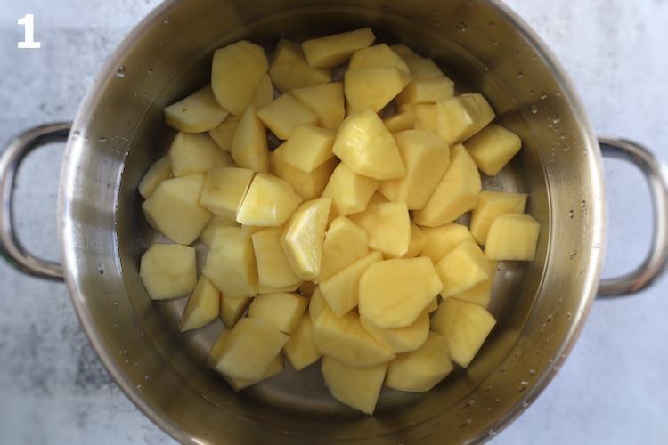 Batatas cortadas em pequenos pedaços num tacho com água temperada com sal