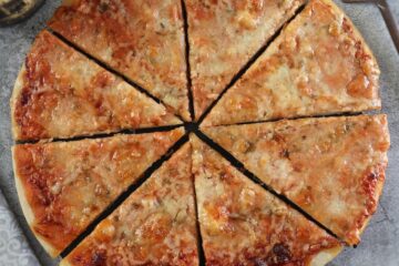 Fatias de pizza de queijo caseira numa mesa