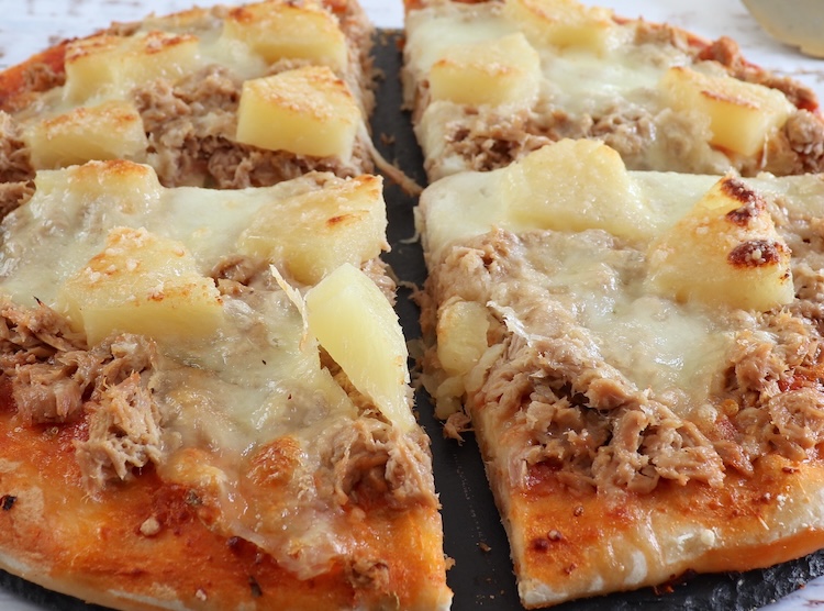 Pizza de queijo caseira com atum e ananás numa mesa