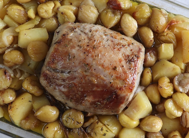 Roasted pork loin with chestnuts on a glass baking dish
